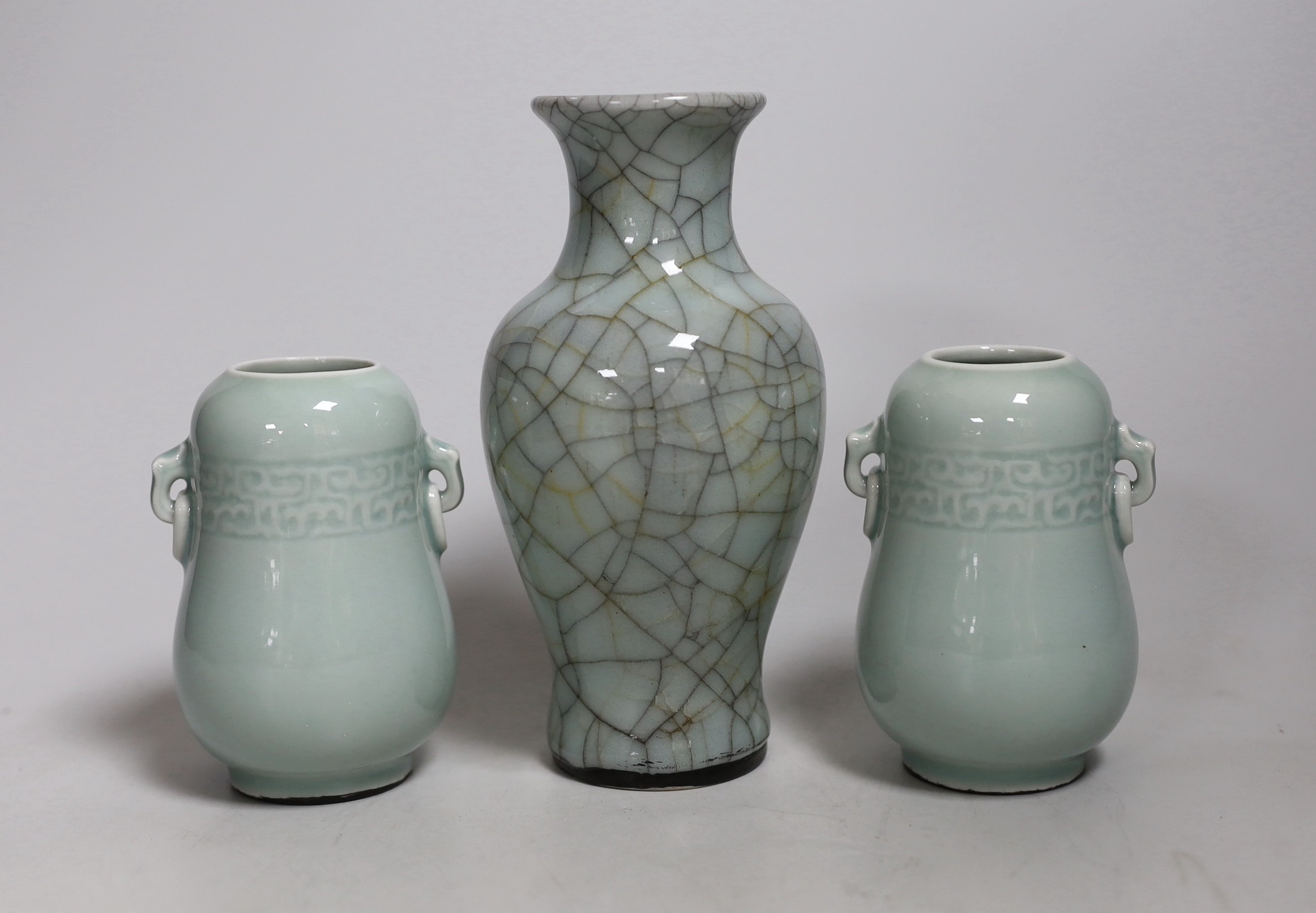 A Chinese celadon crackle ware vase and a pair of smaller celadon vases, largest 16.cms
